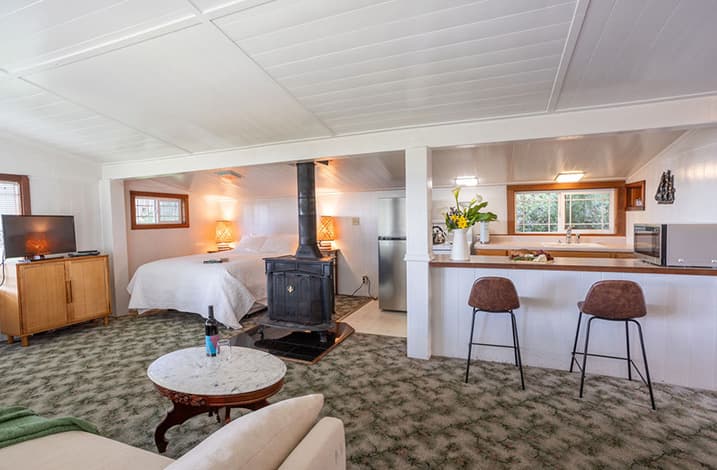 Mendocino Cottages - Quail Cottage fireplace, bed and kitchen